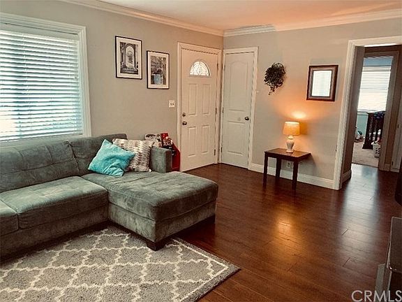 Another view of the living room from the dining area toward the front door and hallway to the bedrooms. Lovely new laminate floo