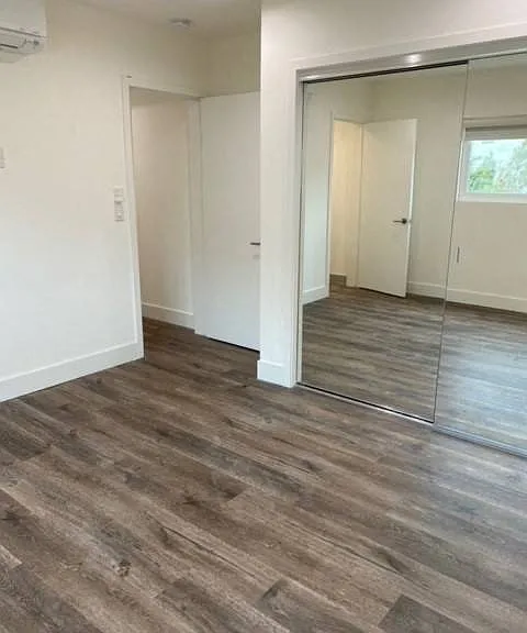 Bedroom with Mirrored Closet and Vinyl Flooring