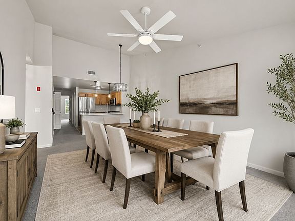 Virtually staged dining area showing one possible furniture layout and the open connection to the kitchen.
