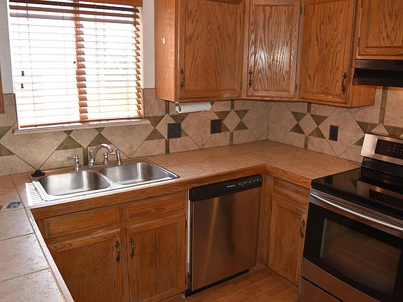 Kitchen complete with tile countertops and tile backsplash.