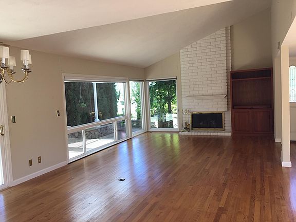 Open living room and dining room feature hardwood floors and lots of natural light
