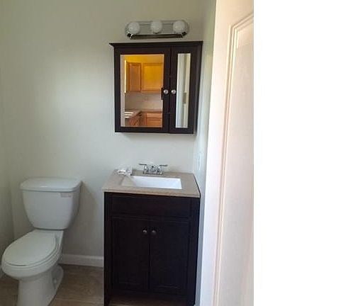 Updated half bath with dark wood espresso finish vanity and