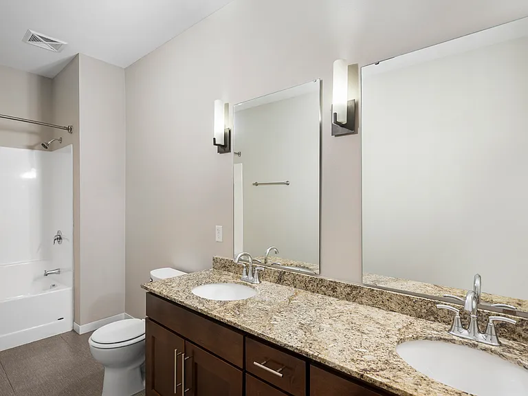 Modern bathroom with elegant granite countertops, dual sinks, and sleek lighting for a luxurious experience. Modern bathroom with elegant granite countertops, dual sinks, and sleek lighting for a luxurious experience.