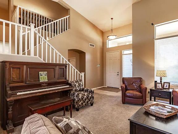 Separate sitting room with soaring ceilings and an antique upright piano