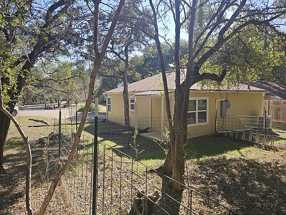 Looking from part of the back yard onto the side porch with fire pit.