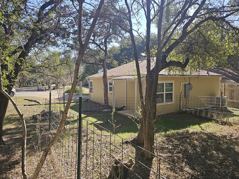 Looking from part of the back yard onto the side porch with fire pit.