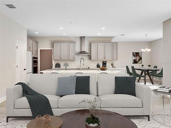 Virtually staged family room open to the kitchen with canopy range hood and quart countertops