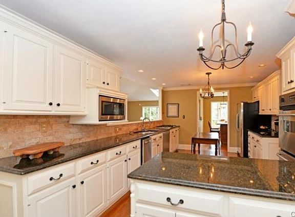 Granite and Stainless Kitchen with hardwood floors has adjacent
