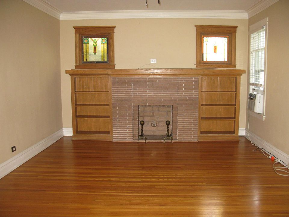 Huge living with gorgeous Prairie style built in bookcase, decorative fireplace and art glass windows.