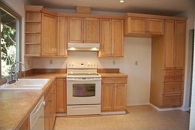 Upper kitchen with maple cabinets and white appliances