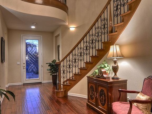 Grand Foyer showcasing Sweeping Staircase with Rod Iron Balusters.