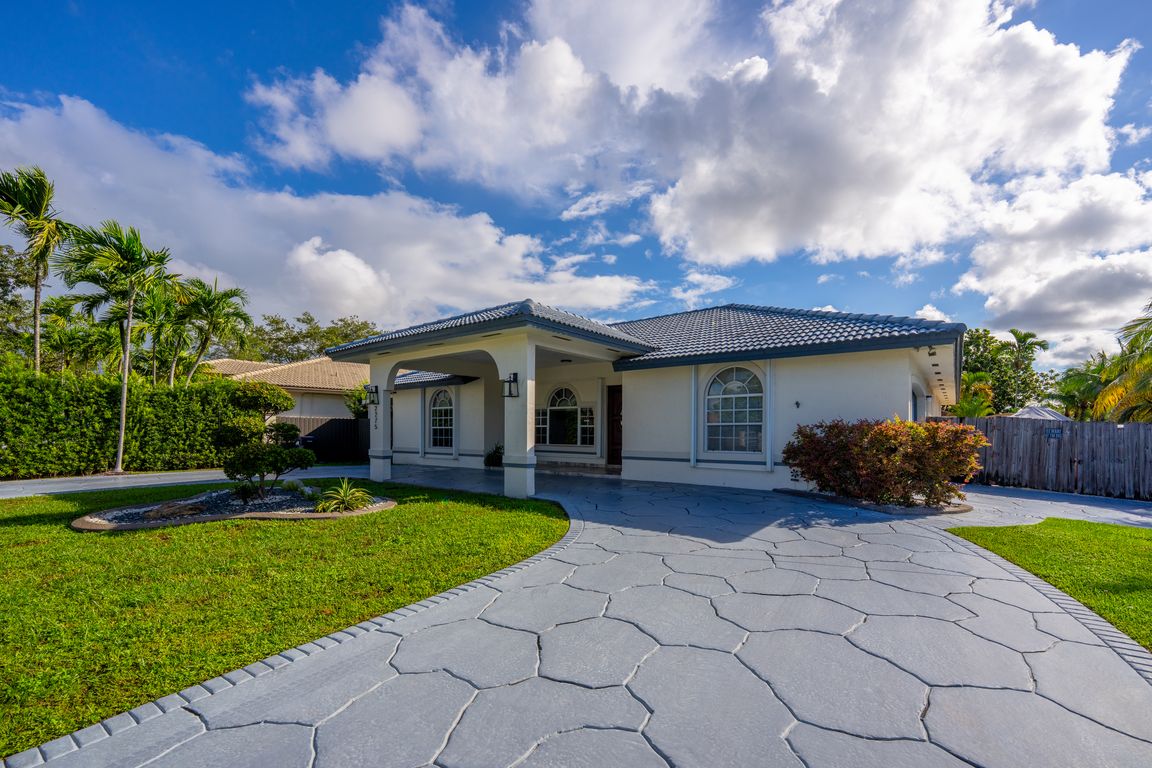 Attractive exterior with arched windows and lush greenery