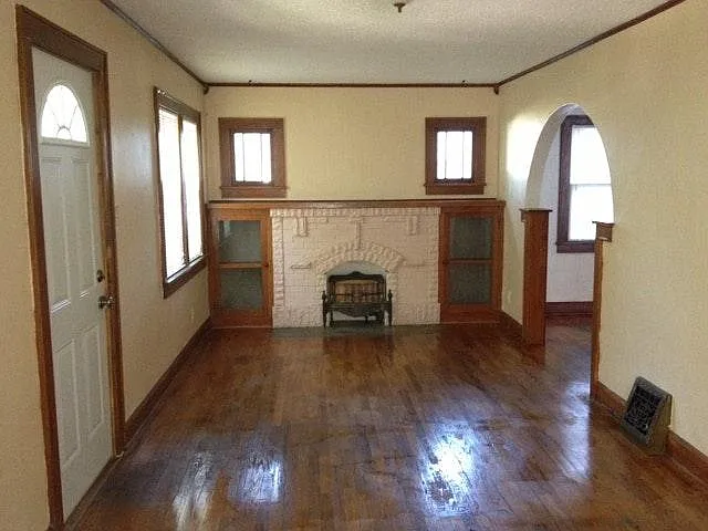 Living room with built-in bookcases and a non-functioning fireplace