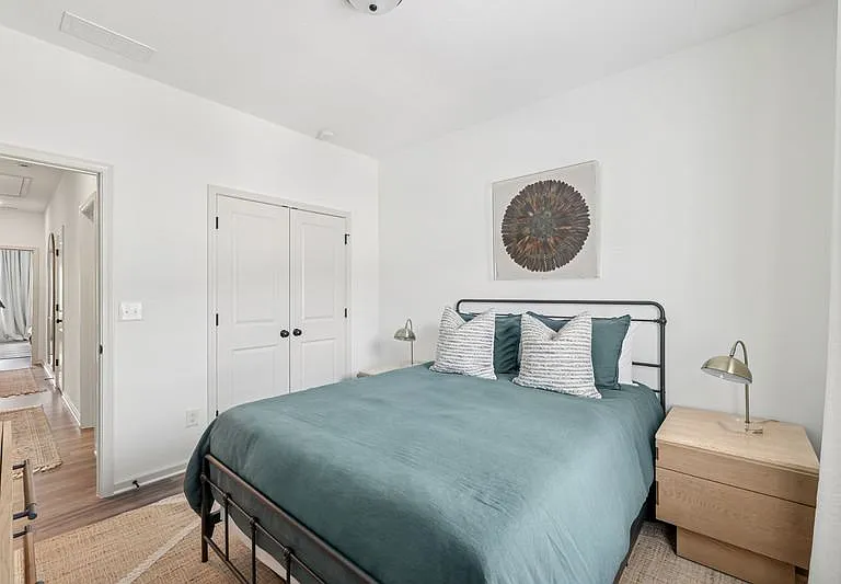 Secondary bedroom with queen size bed and large window letting in a ton of natural light.