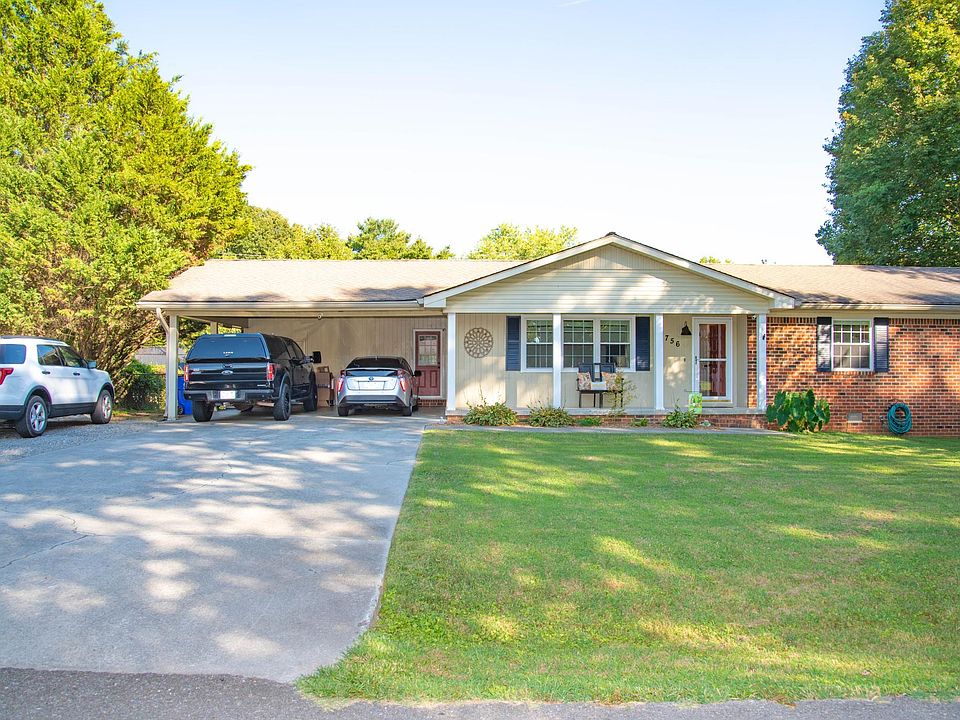 Plenty of parking with additional gravel parking pad beside concrete driveway. Two car carport with storage room.