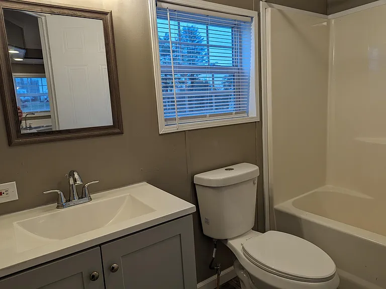 Modern toilet with window and exhaust fan in bathroom