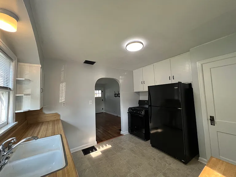 Kitchen with new garbage disposal, gas range and refrigerator.