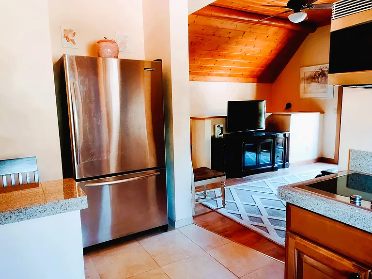 Modern Kitchen with Window over Sink & High Quality Appliances: Convection Microwave, Glass Stovetop, Oversized Refrigerator, Toaster Oven, Electric Tea Kettle, Glass Cabinet Doors, Breakfast Bar & Stools & a vast assortment of Kitchenware, etc.