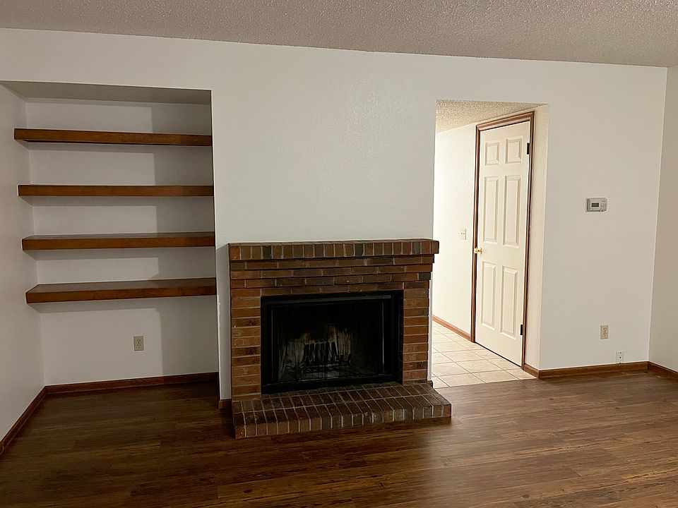 front room with built-in shelves and wood-burning fireplace