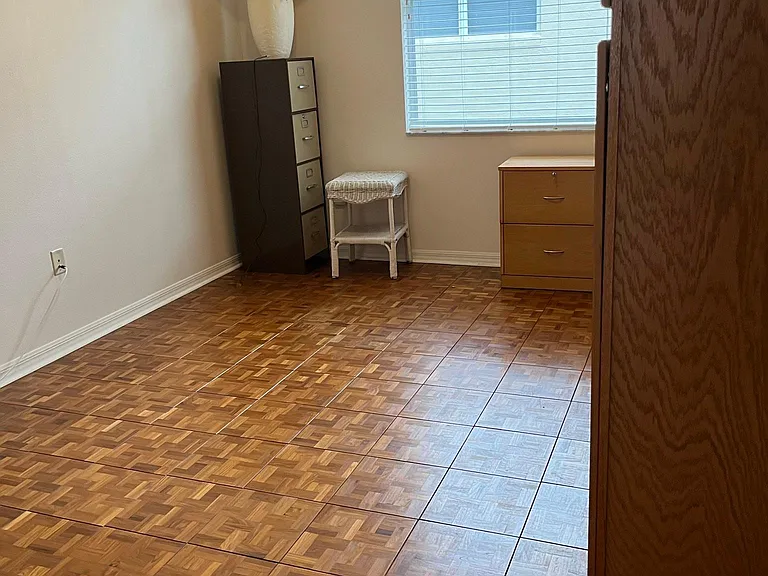 Middle bedroom has wood parquet floors, and a huge wall to wall storage area.