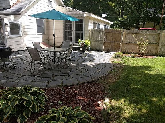 outdoor slate patio in small fenced-in yard in summer
