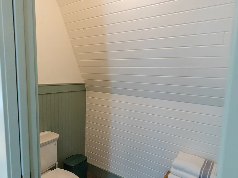 The full bathroom is located on the second floor between the two bedrooms and includes a double vanity, a shower/tub, and a toilet with a pocket door for privacy.
