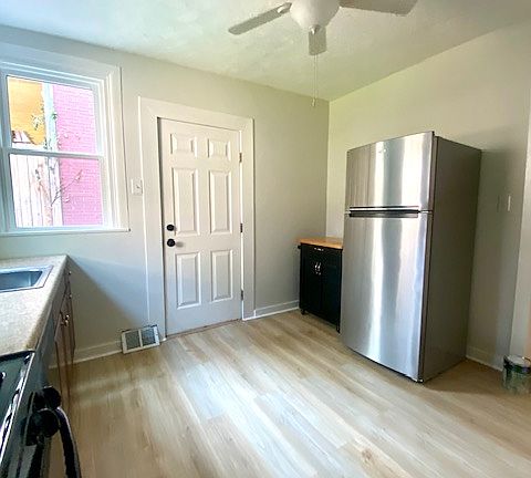 Large bright kitchen with stainless steel refrigerator, new ceiling fan and new flooring