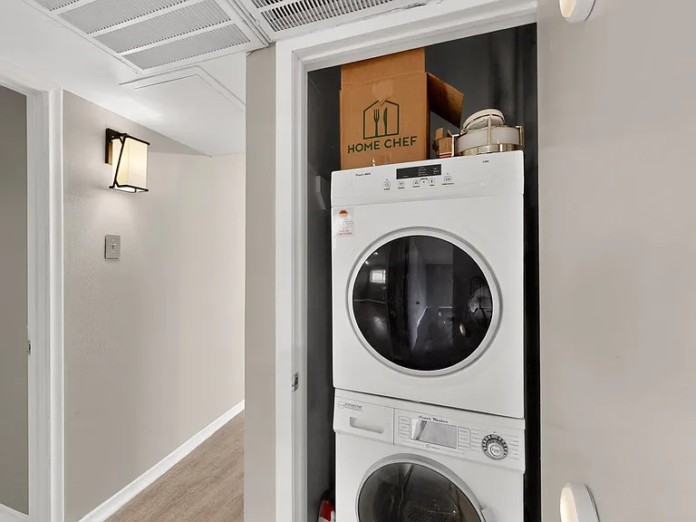 A functional utility closet with a stacked washer and dryer