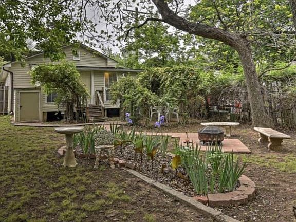 Large landscaped fenced in yard that adjoins a park