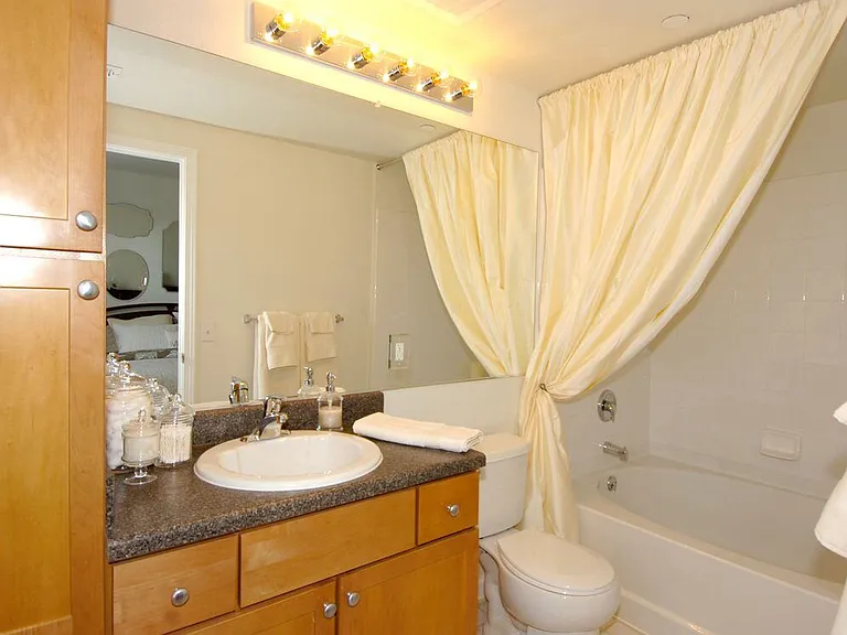 Finish Package I bath with oak cabinetry, black laminate countertops, and hard surface or tile flooring