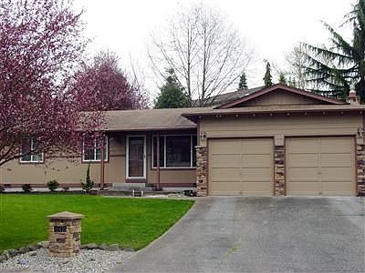 Front of House with stone accents and address pillar 