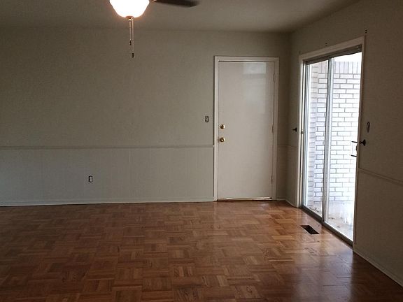 Living Room View of Sliding Glass Patio Door which opens to Backyard and Door to Garage