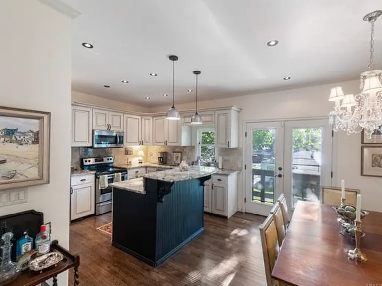 The kitchen is on the entry level, with bar-height seating for two and a pantry. All appliances, including the refrigerator, stay.
