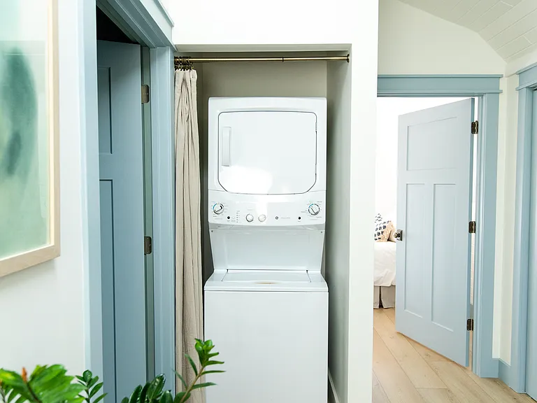 The second floor landing area has a skylight and laundry set up.