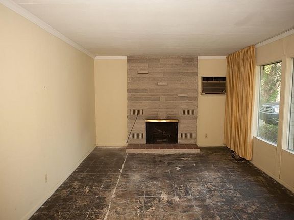 Living room with a wall of windows and a wood burning fireplace