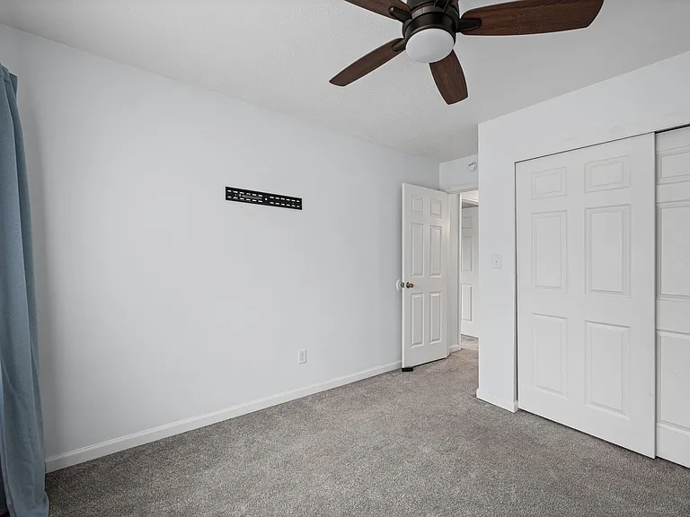 Bedroom 2 with ceiling fan and reach in closet