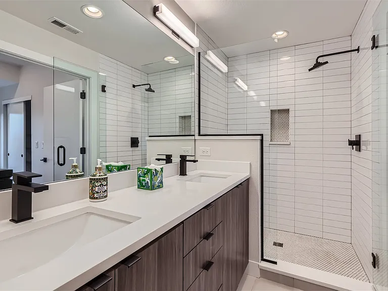 Primary bathroom with double sink and large shower with built-in bench