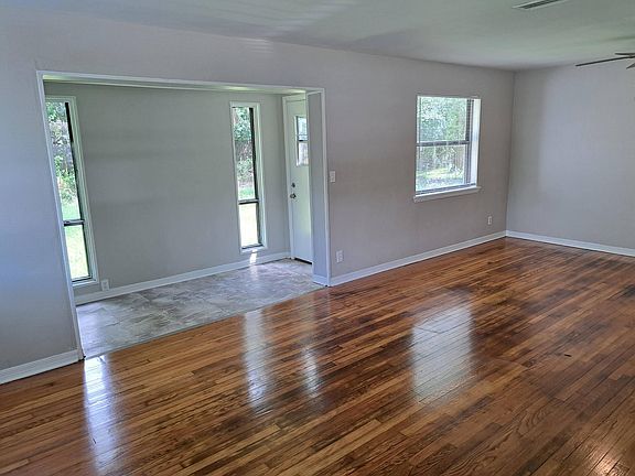 Living and Dining Room. Beautiful refinished real wood floors throughout. View facing rear entrance to spacious backyard.