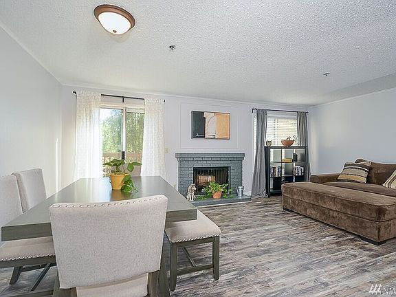 Spacious bright living room with all new flooring  and fireplace and wood deck access.