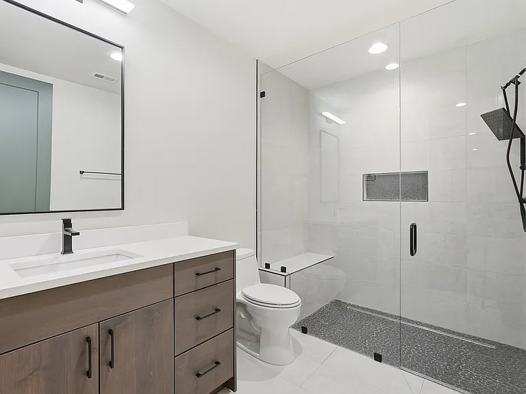 Modern bathroom with walk-in glass shower, sleek vanity, and contemporary finishes.