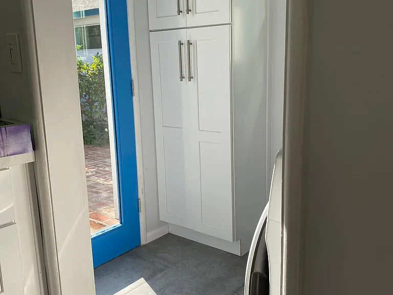 Laundry room pantry storage and door to backyard.