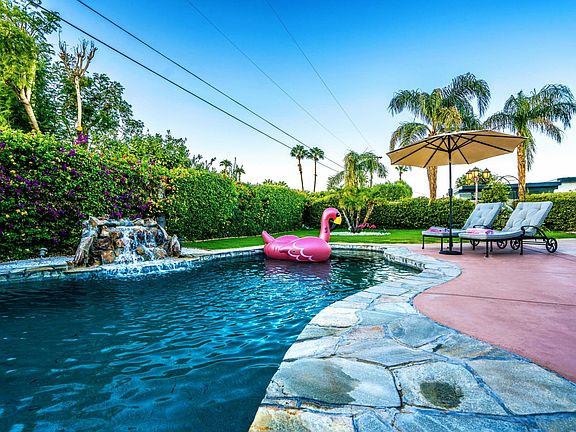 The salt water pool features a relaxing water feature, full privacy on a lush, spacious lot.