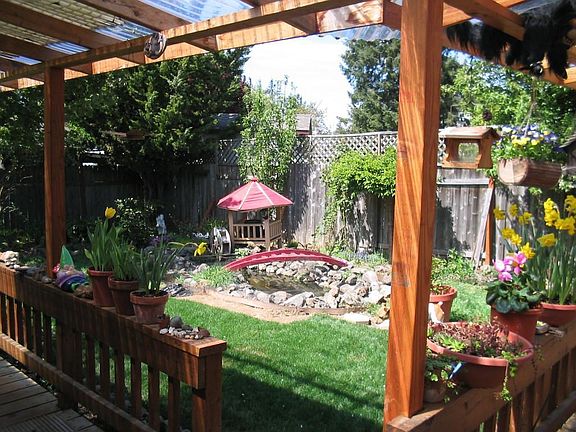 Covered deck overlooking the yard, garden, and pond.