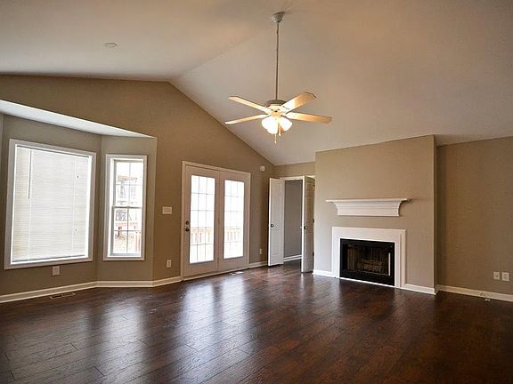 Fireplace and right side of house with french doors leading out to partial wraparound porch.