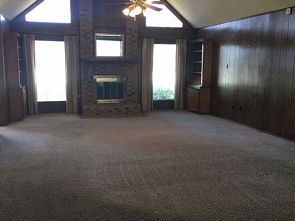 View of living room with fireplace and built in book shelves