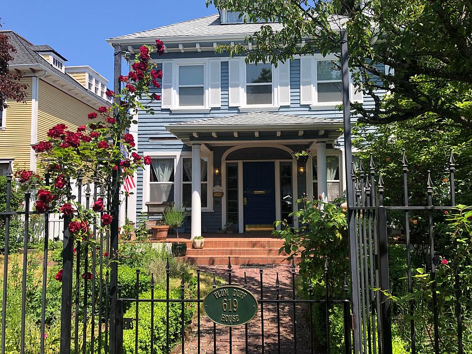 Front Garden | Lovely wild English garden bursting by season with varied ornamental flowers, hedged shrubs, plum and cherry trees, and local PNW greenery.