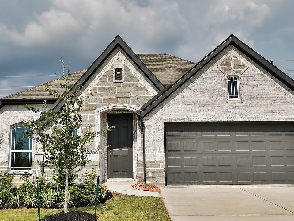 Exquisite stone facade with arched entrance and lush landscaping define luxury in Westland Ranch.