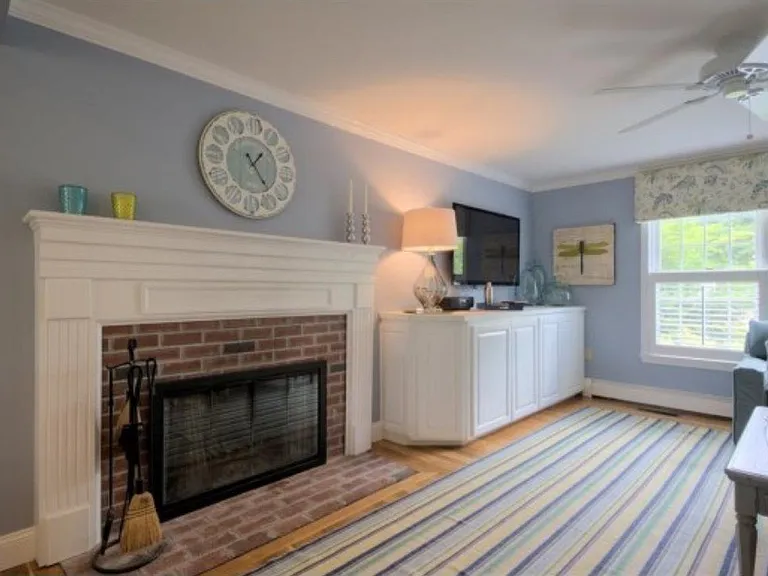 Large flat screen TV and brick wood-burning fireplace