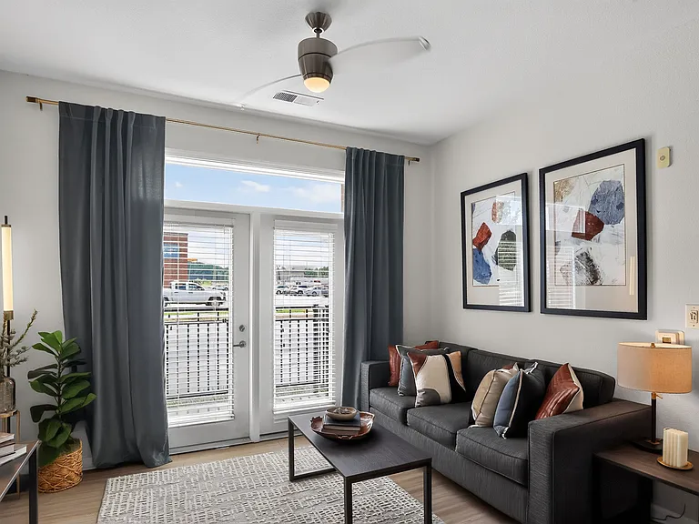 Bright and modern living room featuring a stylish sofa, elegant decor, and large windows with scenic views.