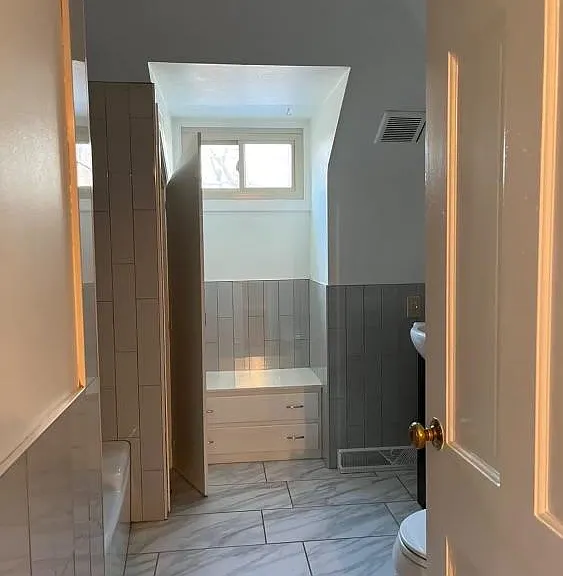 Updated bathroom with built in drawers and spacious linen closet.